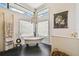 Bright bathroom featuring a freestanding tub, decorative chandelier, and large windows at 506 Crystal Grove Blvd, Lutz, FL 33548