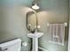 Stylish half bathroom with pedestal sink, modern fixtures, and a fresh color palette at 506 Crystal Grove Blvd, Lutz, FL 33548