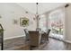 Light-filled dining room features white curtains, wood-look tile flooring, and modern decor at 506 Crystal Grove Blvd, Lutz, FL 33548