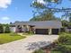 Attractive home featuring a lush front yard, brick driveway, and a two-car garage at 506 Crystal Grove Blvd, Lutz, FL 33548
