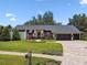 Charming one-story home with a well-manicured lawn, a brick driveway, and colorful landscaping at 506 Crystal Grove Blvd, Lutz, FL 33548