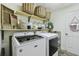 Bright laundry room with modern washer and dryer, floating shelves, and charming decor at 506 Crystal Grove Blvd, Lutz, FL 33548