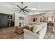 Open-concept living room with a large sectional sofa, vaulted ceiling, and wood flooring at 506 Crystal Grove Blvd, Lutz, FL 33548