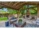 Inviting outdoor patio with a stone fireplace, comfortable seating, and a wooden pergola at 506 Crystal Grove Blvd, Lutz, FL 33548