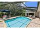 Screened-in pool with brick surround and lounge chairs, perfect for enjoying sunny days at 506 Crystal Grove Blvd, Lutz, FL 33548