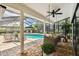 Covered porch features a screened lanai, ceiling fan, and a view of the pool at 506 Crystal Grove Blvd, Lutz, FL 33548