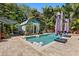 Backyard pool area surrounded by tropical landscaping, pavers, lounge furniture, and a shed at 5127 29Th S Ave, Gulfport, FL 33707