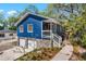 Charming blue home with a stone foundation, a welcoming porch, and a well-manicured yard at 5413 N Park Pl, Tampa, FL 33603