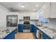 Bright kitchen boasts granite counters, stainless appliances, blue cabinets, and wood-look floors at 5413 N Park Pl, Tampa, FL 33603