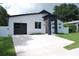 Modern home features clean lines, minimalist landscaping, and a black garage door for striking curb appeal at 5518 Newton S Ave, Gulfport, FL 33707