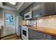 Well-equipped kitchen with stainless steel appliances, butcher block counters, and gray cabinetry at 5876 21St N St # 10, St Petersburg, FL 33714