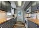 Galley kitchen featuring gray cabinets, wood counters, modern appliances, and subway tile backsplash at 5876 21St N St # 10, St Petersburg, FL 33714