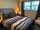 Comfortable bedroom featuring a queen bed and soft lamp lighting at 5990 Terrace Park N Dr # 109, St Petersburg, FL 33709