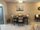 Dining area with a dark wood table, four chairs, and a large painting on the wall at 5990 Terrace Park N Dr # 109, St Petersburg, FL 33709