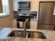 Updated kitchen with stainless steel appliances, granite countertops, and a modern faucet at 5990 Terrace Park N Dr # 109, St Petersburg, FL 33709