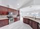 Charming kitchen featuring wood cabinetry, stainless steel appliances, and tiled backsplash at 6208 Bridgevista Dr, Lithia, FL 33547