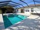 Screened pool area featuring a clear pool with a connecting jacuzzi, tiled border, and outdoor seating area at 6208 Bridgevista Dr, Lithia, FL 33547