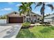 Beautiful home with a well-manicured lawn, mature trees, and eye-catching stone exterior accents at 6592 Mango S Ave, St Petersburg, FL 33707
