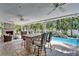 Covered outdoor bar overlooking a pool with a waterfall feature in a private backyard at 6592 Mango S Ave, St Petersburg, FL 33707
