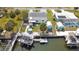 Aerial view showcases a house with waterfront access, boat dock, tiki hut, and manicured landscaping at 6801 Clark St, Hudson, FL 34667