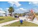 Beautifully landscaped backyard with a waterfront view, tiki hut, and lush green lawn at 6801 Clark St, Hudson, FL 34667