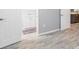Hallway with grey floor tiles, leading into a bathroom with white cabinets at 6801 Clark St, Hudson, FL 34667
