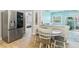Kitchen area with stainless steel refrigerator, breakfast table and chairs, and view to the bedroom at 6801 Clark St, Hudson, FL 34667