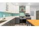 Modern kitchen featuring stainless steel appliances, white countertop, and teal tile backsplash at 6801 Clark St, Hudson, FL 34667