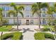 Charming building exterior with manicured lawn and mature palm trees at 701 Mirror Lake N Dr # 119, St Petersburg, FL 33701