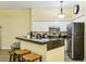 Kitchen with a breakfast bar that offers seating for three and stainless steel appliances at 701 Mirror Lake N Dr # 119, St Petersburg, FL 33701
