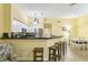 Bright open kitchen with white cabinets, black countertops, stainless steel appliances, and bar stool seating at 701 Mirror Lake N Dr # 119, St Petersburg, FL 33701