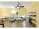 A bright and airy living room with a sofa, chairs, a table and a large ceiling fan at 701 Mirror Lake N Dr # 119, St Petersburg, FL 33701
