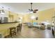 A fully furnished living room with natural light, with a kitchen island and barstool seating at 701 Mirror Lake N Dr # 119, St Petersburg, FL 33701
