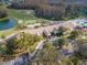 Aerial view of community clubhouse, pool, and golf course with lush green landscaping at 7441 Trovita Rd, Land O Lakes, FL 34637