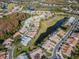 Aerial view of homes with golf course and water view in a serene community at 7441 Trovita Rd, Land O Lakes, FL 34637