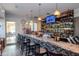 Stylish bar area with a well-stocked counter, stools, and a large TV at 7441 Trovita Rd, Land O Lakes, FL 34637