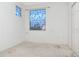 Empty bedroom with stained carpet and two unique and colorful windows at 7441 Trovita Rd, Land O Lakes, FL 34637