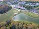 Aerial view of clubhouse with pool, golf course and pond at 7441 Trovita Rd, Land O Lakes, FL 34637