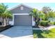 Two car garage door with lush landscaping and front yard at 7441 Trovita Rd, Land O Lakes, FL 34637