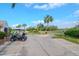 Golf course entrance with palm trees, a parked golf cart, and lush green scenery at 7441 Trovita Rd, Land O Lakes, FL 34637