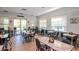 Casual dining area with multiple tables, chairs, and natural light from large windows at 7441 Trovita Rd, Land O Lakes, FL 34637