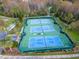 Aerial view of well-maintained tennis courts, surrounded by lush landscaping in a vibrant community at 7441 Trovita Rd, Land O Lakes, FL 34637