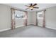 Bright bedroom with a ceiling fan, soft carpet, and two windows featuring colorful curtains at 783 41St Ne Ave, St Petersburg, FL 33703