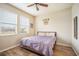 Bright bedroom with wood floors, two windows with blinds, and overhead fan at 810 Fern Leaf Dr, Ruskin, FL 33570