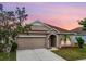 Charming single-story home with a well-maintained lawn and a two-car garage under a lovely dusk sky at 810 Fern Leaf Dr, Ruskin, FL 33570
