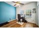 Office with wood floors, a blue accent wall, and two windows with blinds at 810 Fern Leaf Dr, Ruskin, FL 33570