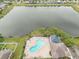 Community pool overlooking lake; offers a serene retreat and leisure for residents at 810 Fern Leaf Dr, Ruskin, FL 33570