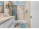 Clean bathroom featuring a vanity with a stone countertop, decorative mirrors, and a shower-tub combination at 911 Harbour House Dr, Indian Rocks Beach, FL 33785