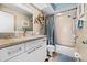 Clean bathroom featuring a vanity with a stone countertop, decorative mirrors, and a shower-tub combination at 911 Harbour House Dr, Indian Rocks Beach, FL 33785