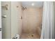 Walk-in shower featuring tan tiling, a rainfall shower head, and a built in bench at 911 Harbour House Dr, Indian Rocks Beach, FL 33785